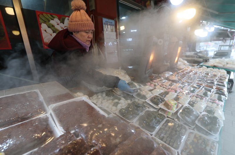 올겨울 첫 한파특보가 내려진 3일 경기 수원시 팔달구 수원영동시장 인근 떡집에서 상인들이 갓 나온 떡을 진열하고 있다. 2025.12.3/뉴스1 ⓒ News1 김영운 기자