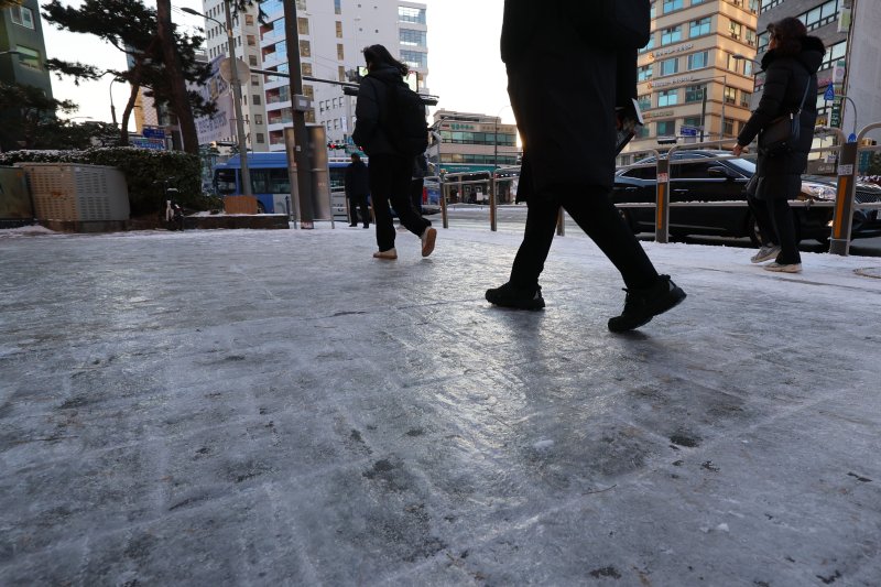 [서울=뉴시스] 권창회 기자 = 폭설 후 한파로 도로 곳곳이 얼어붙은 5일 오전 서울 중구 충무로역 인근에서 시민들이 빙판길을 조심히 걷고 있다. 2025.12.05. kch0523@newsis.com