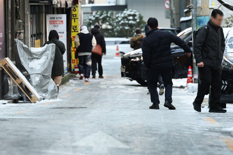[서울=뉴시스] 권창회 기자 = 폭설 후 한파로 도로 곳곳이 얼어붙은 5일 오전 서울 중구 충무로역 인근에서 시민들이 빙판길을 조심히 걷고 있다. 2025.12.05. kch0523@newsis.com