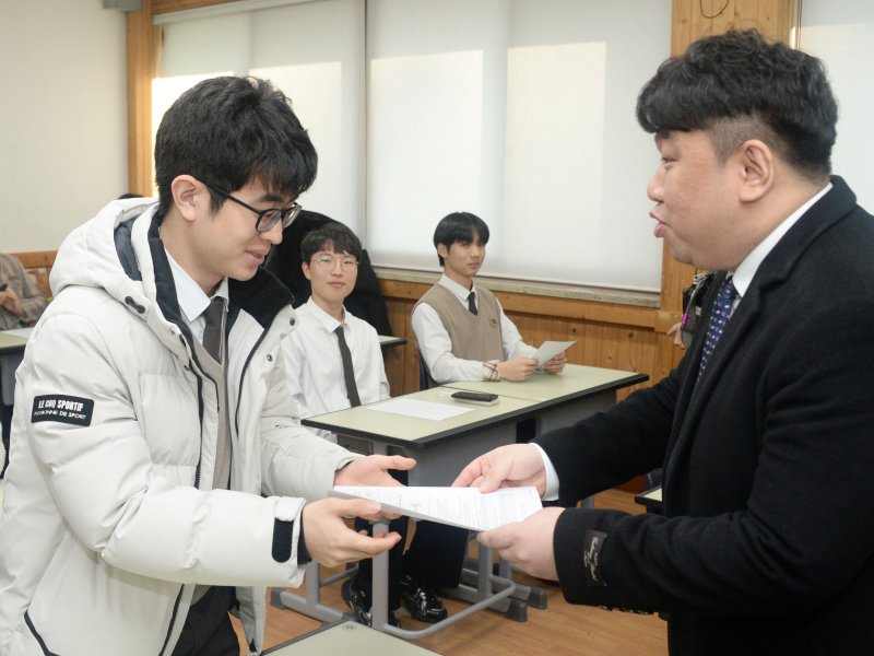 [전주=뉴시스] 김얼 기자 = 2026학년도 대학수학능력시험 성적표 배부일인 5일 전북 전주시 전주한일고등학교에서 수능 만점자 이하진(왼쪽) 학생이 선생님에게 성적표를 받고 있다. 2025.12.05. pmkeul@newsis.com