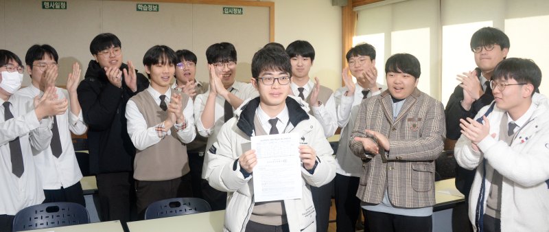 [전주=뉴시스] 김얼 기자 = 2026학년도 대학수학능력시험 성적표 배부일인 5일 전북 전주시 전주한일고등학교에서 수능 만점자 이하진(가운데) 학생이 친구들의 응원을 받고 있다. 2025.12.05. pmkeul@newsis.com