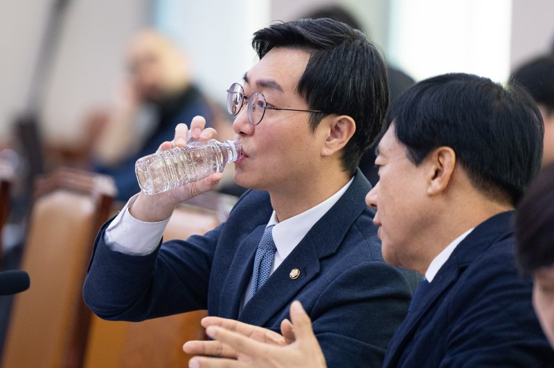 장경태 더불어민주당 의원이 5일 서울 여의도 국회에서 열린 제429회 국회(정기회) 법제사법위원회 제9차 법안심사제1소위원회에서 이성윤 의원과 대화하며 물을 마시고 있다. 2025.12.5/뉴스1 ⓒ News1 유승관 기자
