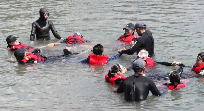 지난 7월 제주 서귀포시 법환어촌계 해녀체험장에서 강정초등학교 학생들이 해녀와 해군 해난구조대(SSU)로부터 '제주형 생존수영' 교육을 받고 있다. 2025.7.8/뉴스1 DB