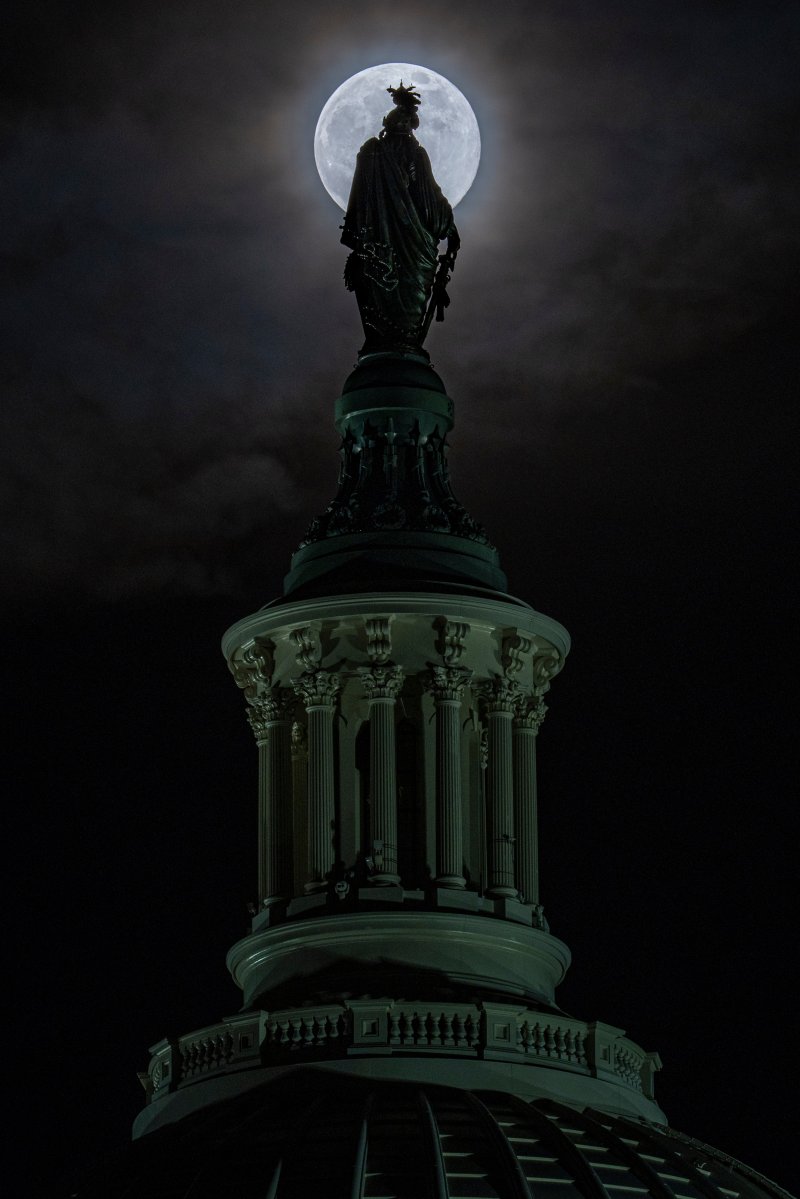 [워싱턴=AP/뉴시스] 4일(현지 시간) 미국 워싱턴에서 올해 마지막 보름달인 ‘콜드 슈퍼문’이 의사당 돔 꼭대기 '자유상'(Statue of Freedom) 뒤로 떠오르고 있다. 2025.12.05.