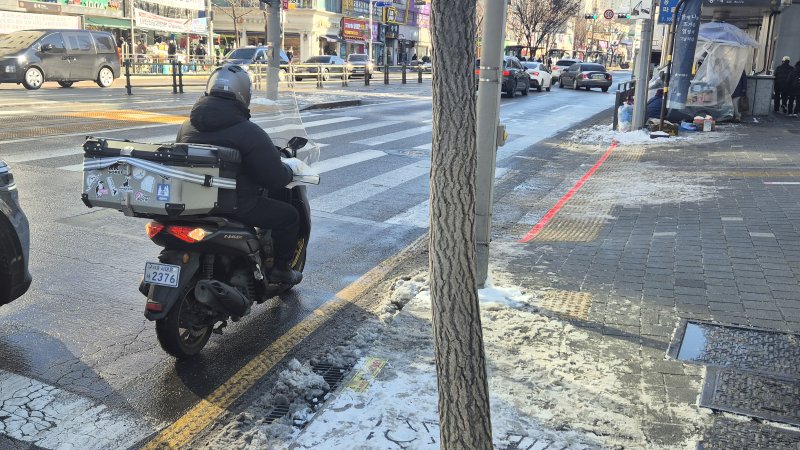 [서울=뉴시스]이종성 수습기자=5일 오전 서울 서대문구 홍제역 인근에서 배달기사가 빙판길 위 운전을 하고 있다. bsg05107@newsis.com 2025.12.05