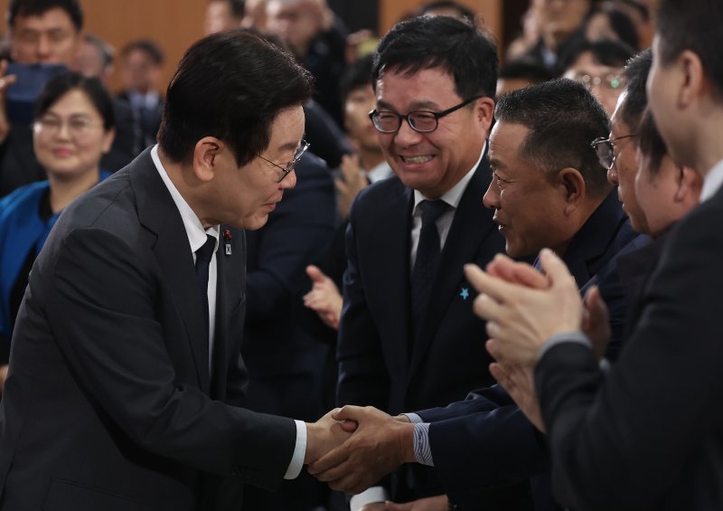 [천안=뉴시스] 고범준 기자 = 이재명 대통령이 5일 충남 천안시 한국기술교육대학교에서 열린 '충남의 마음을 듣다' 타운홀미팅에 입장하며 참석자들과 악수하고 있다. (대통령실통신사진기자단) 2025.12.05. bjko@newsis.com