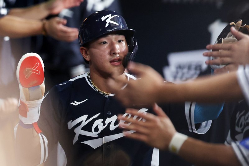 한국 3회초 공격 1사 주자 2, 3루서 문보경의 내야 땅볼 때 3루 주자 안현민이 홈인한 뒤 더그아웃에서 동료들과 하이파이브하고 있다.