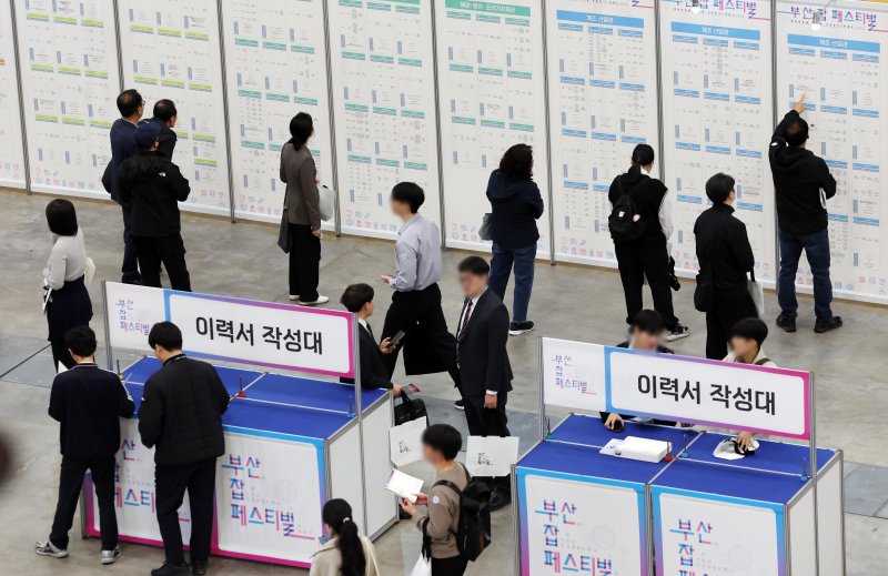 [부산=뉴시스] 하경민 기자 = '2025 부산 잡(JOB) 페스티벌'이 열린 27일 부산 해운대구 벡스코 제1전시장에서 구직자들이 이력서를 작성하거나 채용기업 현황판을 둘러보고 있다. 이날 행사에는 공공기관 10곳을 포함한 기업 총 215곳이 참가해 구직자를 상대로 현장 면접, 채용 상담 등을 진행했다. 또 채용관, 홍보관, 컨설팅관, 체험관, 취업특강·기업설명회, 부대행사 등 다양한 프로그램을 운영했다. 2025.10.27. yulnetphoto@newsis.com