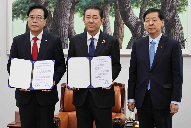 [서울=뉴시스] 조성봉 기자 = 김병기 더불어민주당 원내대표와 송언석 국민의힘 원내대표가 2일 서울 여의도 국회에서 2026년도 예산안 처리를 위한 합의문에 서명을 마치고 기념촬영을 하고 있다. 오른쪽은 구윤철 경제부총리 겸 기획재정부 장관. (공동취재) 2025.12.02. photo@newsis.com