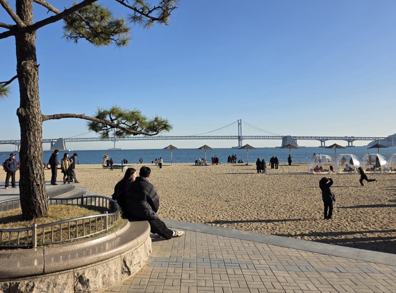 6일 오후 부산 광안리해수욕장 인근에 시민들이 앉아있다.2025.12.6/뉴스1 ⓒ News1 장광일 기자