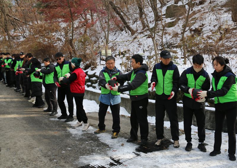 기동호 사장(사진 우측 다섯번 째)과 코리아에셋투자증권 임직원들이 6일 밥상공동체복지재단(서울연탄은행)과 함께 서울 상계동 일대에서 에너지 소외계층을 위한 사랑의 연탄 나눔 활동을 진행했다. 코리아에셋투자증권 제공.