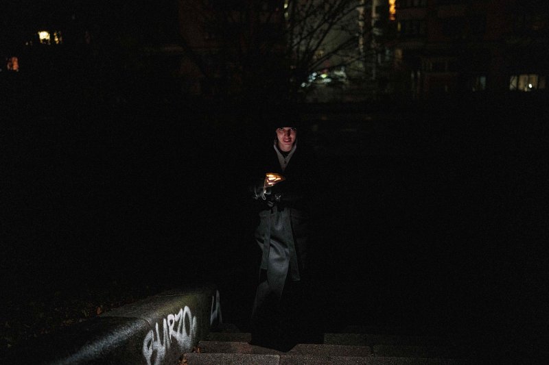 [키이우=AP/뉴시스] 지난달 20일(현지 시간) 러시아군의 에너지 시설 공격으로 정전된 우크라이나 키이우에서 한 여성이 휴대전화 불빛에 의지해 거리를 걷고 있다. 2025.12.07.