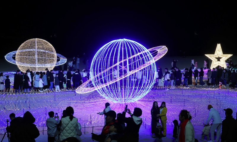 [부산=뉴시스] 하경민 기자 = '제12회 해운대빛축제' 점등식이 열린 29일 부산 해운대구 해운대해수욕장에서 시민과 관광객들이 백사장 180m 구간에 우주를 형상화한 빛 조형물을 구경하고 있다. 해운대구 구남로와 해운대해수욕장 일대에서 열리는 이번 축제는 내년 1월18일까지 계속된다. 2025.11.30. yulnetphoto@newsis.com