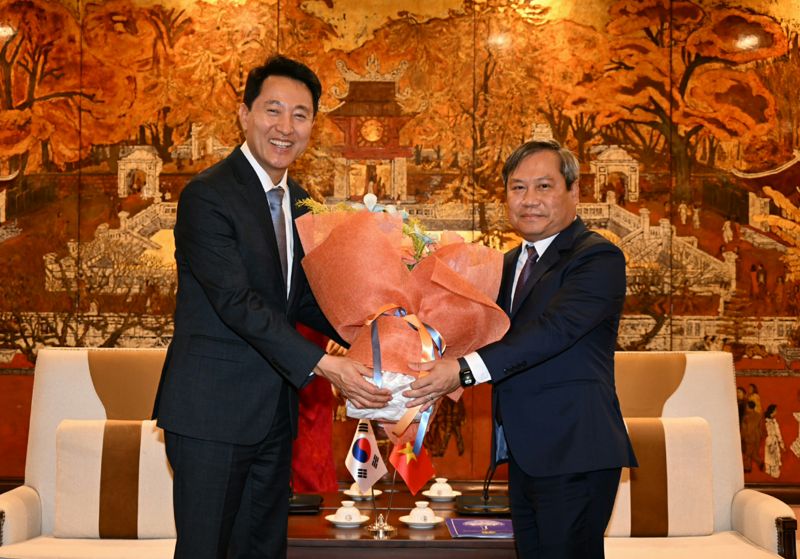 지난 5일 하노이 인민위원회를 찾은 오세훈 서울시장(왼쪽)이 부 다이 탕 하노이 신임 인민위원장(오른쪽)에게 취임 축하 꽃다발을 전하고 있다. 서울시 제공