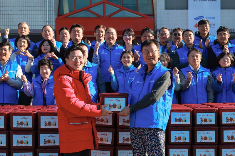 [거제=뉴시스] 신정철 기자= 삼성중공업은 지난 6일, 사내 문화관에서 임직원과 고객, 대외 봉사단체와 함께하는 '2025년 행복나눔 김치데이'를 개최했다.사진은 최성안 삼성중공업 대표이사 부회장(오른쪽)이 박은덕 경남사회복지공동모금회 사무처장에게 임직원 등이 직접 담근 김장 김치 6500포기를 전달하는 모습.(사진=삼성중공업 제공).2025.12.07. photo@newsis.com *재판매 및 DB 금지