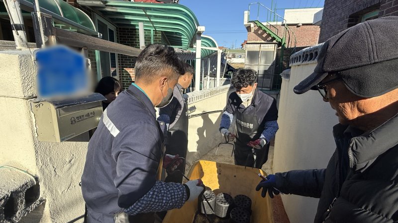 손창환 강원도글로벌본부장(사진 가운데)이 지난 5일 주문진읍 일원에서 진행된 연탄나눔 봉사활동에 참여해 주민들에게 연탄을 나눠주고 있다.(강원도제2청사 제공, 재판매 및 DB 금지) 2025.12.7/뉴스1