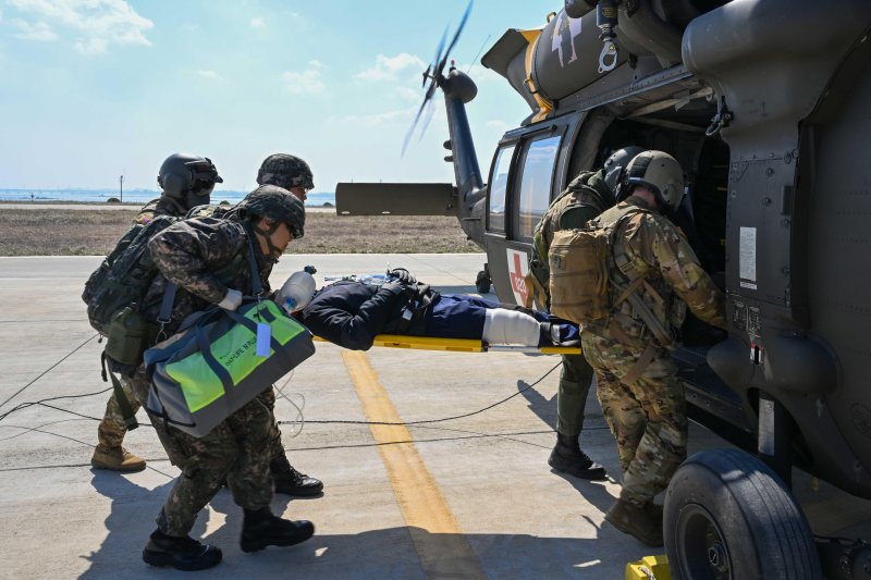 [서울=뉴시스] 13일 서해 덕적도에서 자유의 방패(FS) 연습 일환으로 진행된 전시 한미 연합 의무지원훈련에서 해군 2함대 군 의료진이 중증 외상환자를 국군대전병원으로 후송하기 위해 미군 탐색구조헬기(HH-60)에 탑승시키고 있다. (사진=해군 제공) 2024.03.14. photo@newsis.com *재판매 및 DB 금지