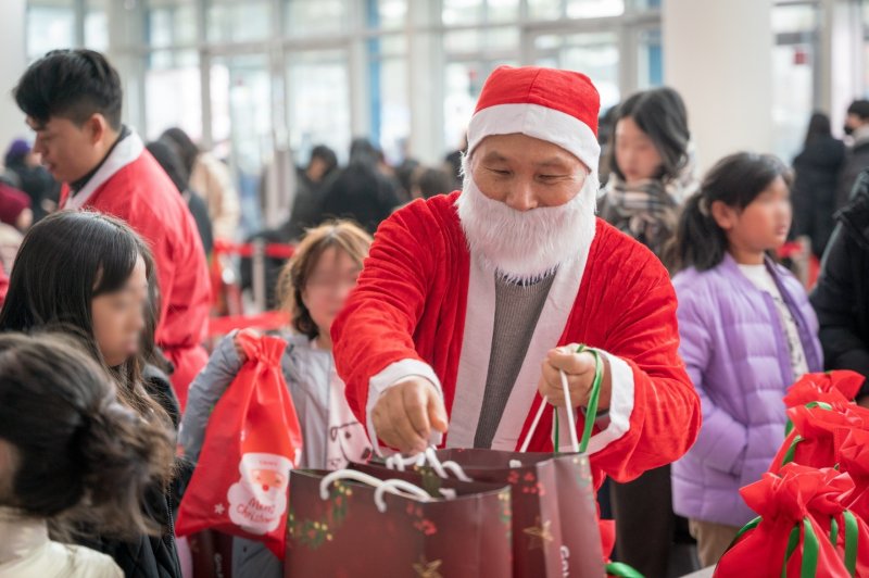 골프존문화재단이 6일 충남대학교 정심화국제문화회관 정심화홀에서 2025 희망행복나눔 페스티벌'을 진행했다. 산타복장을 한 김영찬 이사장이 아이들에게 선물을 나눠주고 있는 모습. (골프존 제공)