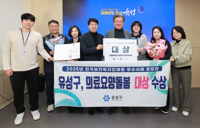 [대전=뉴시스] 조명휘 기자 = 대전 유성구 직원들이 ‘2025년 의료요양돌봄 통합지원 성과대회’에서 의료·요양·돌봄 우수사례 대상을 받은 것을 기념해 사진촬영을 하고 있다. (사진= 유성구 제공) 2025.12.08. photo@newsis.com *재판매 및 DB 금지