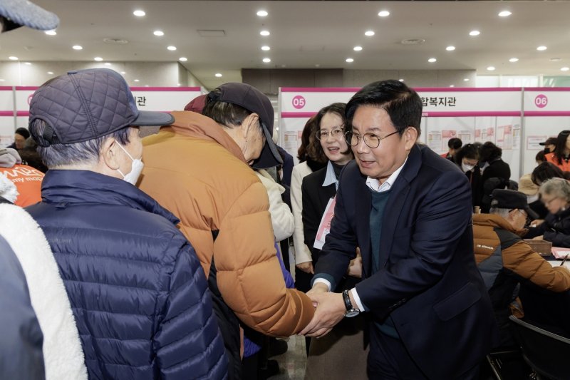 박강수 마포구청장이 지난해 '2025 마포구 노인일자리 박람회'에서 어르신들과 인사를 나누고 있다.