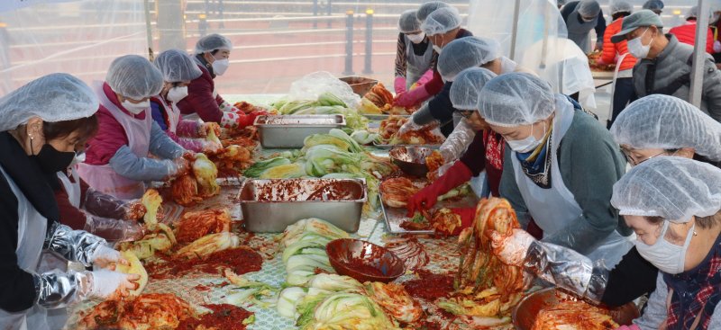 [영동=뉴시스] 충북 영동군장애인복지관 직원과 복지관 이용인, 영동난계로타리클럽 회원, 한국수력원자력 직원 등이 8일 오전 복지관 주차장에서 ‘사랑의 김장'을 하고 있다. 이들은 10㎏ 들이 배추 170상자 분량의 김치를 담가 재가 장애인 등에게 전달했다. (사진=영동군 제공) 2025.12.08. photo@newsis.com *재판매 및 DB 금지