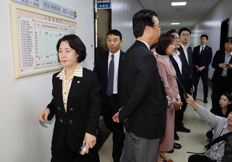 [서울=뉴시스] 김명년 기자 = 추미애 국회 법제사법위원장이 22일 오전 서울 여의도 국회 법사위원장실 앞에서 기자회견하는 나경원 국민의힘 의원 등을 지나쳐 회의실로 향하고 있다. 2025.09.22. kmn@newsis.com