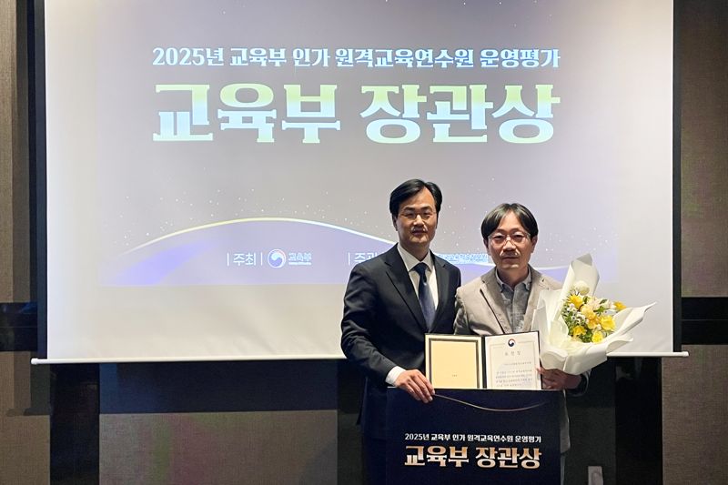 이상학 아이스크림미디어 교육사업실 실장(오른쪽)이 교육부장관상 수상 후 이종원 교육부 교원양성연수과 과장과 기념촬영을 하고 있다. 아이스크림미디어 제공