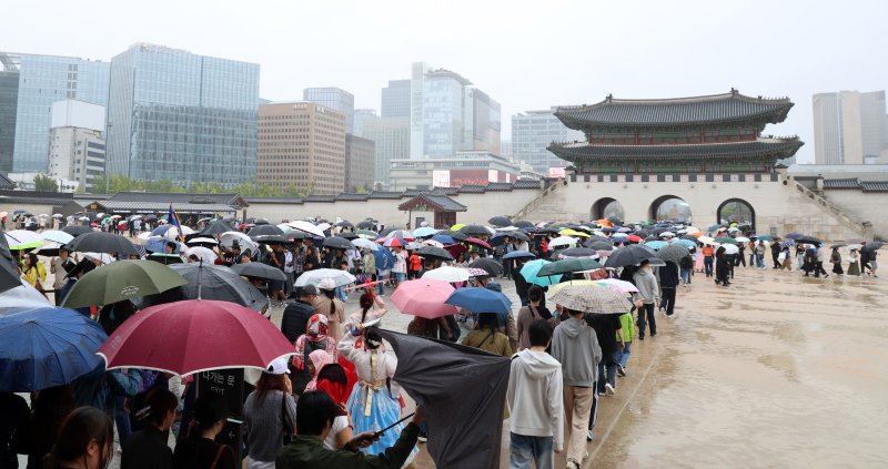 서울 종로구 경복궁에서 비가 내리는 가운데 시민들과 외국인 관광객들이 나들이를 하고 있다. 2025.10.6/뉴스1 ⓒ News1 김명섭 기자