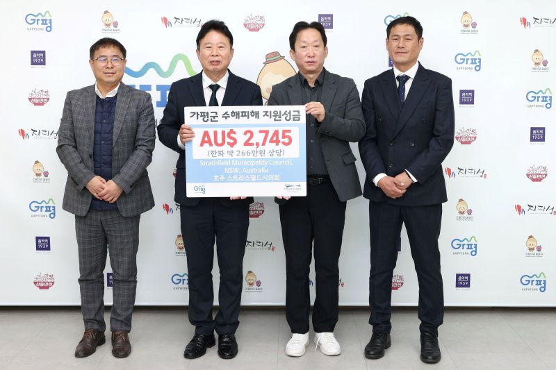 호주 뉴사우스웨일스주 스트라스필드시가 경기 가평군에 전달한 수해 성금. 서태원 군수가 기념사진을 찍고 있다.(가평군 제공. 재판매 및 DB 금지)/뉴스1