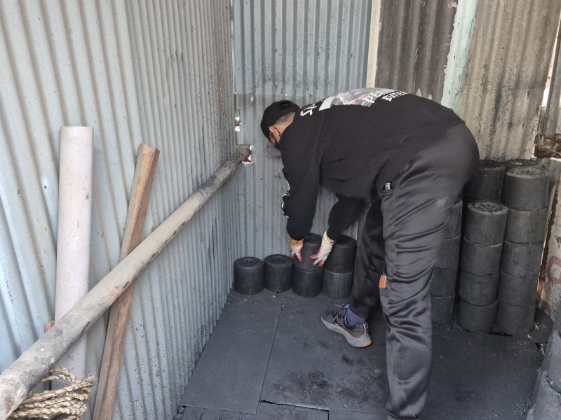 열린마음봉사단이 7일 울산 남구 선암동의 한 마을에서 에너지취약 계층의 창고에 연탄을 쌓고 있다.202512.8/뉴스1ⓒ 뉴스1 박정현 기자