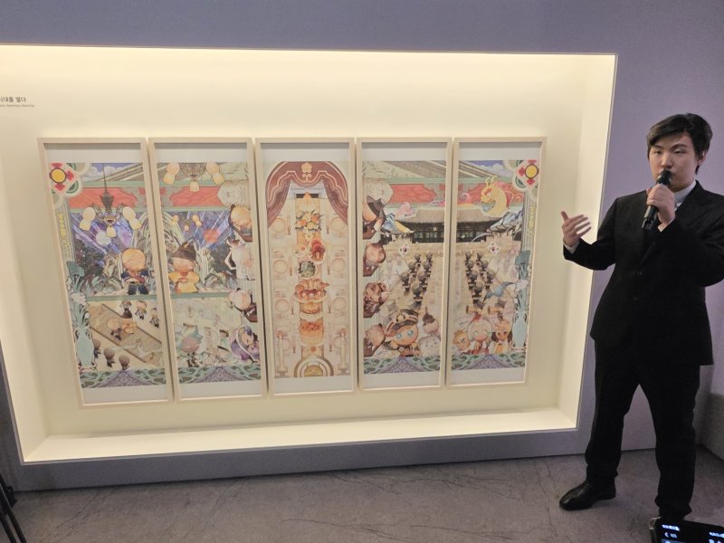 [서울=뉴시스]오동현 기자 = 조길현 데브시스터즈 대표가 8일 서울 중구 덕수궁 돈덕전에서 '쿠키런: 사라진 국가유산을 찾아서' 특별전 기자간담회를 열고 다섯 폭 병풍 형식의 '쿠키런 상상화 2: 칭경예식, 새 시대를 열다'를 소개하고 있다. 2025.12.08. odong85@newsis.com
