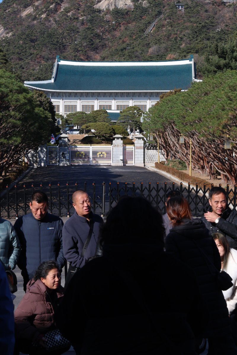 [서울=뉴시스] 이영환 기자 = 대통령실이 용산 대통령 집무실을 청와대로 이전하는 작업을 본격적으로 시작한 8일 오후 서울 종로구 청와대 앞에서 관광객들이 기념촬영을 하고 있다.2022년 5월 윤석열 정부 출범과 함께 시작된 '용산 시대'가 3년 7개월 만에 막을 내리는 것으로 성탄절께 업무시설 이전을 마무리할 계획이다. 2025.12.08. 20hwan@newsis.com