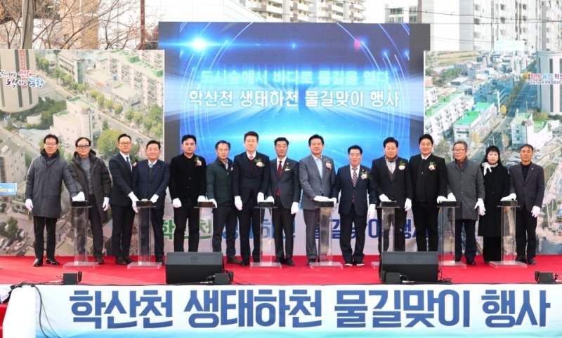 [포항=뉴시스] 송종욱 기자 = 8일 '학산천 생태 하천 복원 사업' 준공을 앞두고 북구 학산동 학산천 출발점에서 물길맞이 행사가 열린 가운데 참석자들이 통수식 퍼포먼스를 하고 있다. (사진=포항시 제공) 2025.12.08. photo@newsis.com