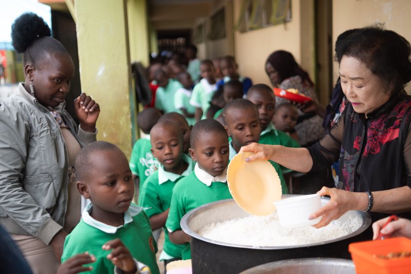 지난 2월 윤영순씨(오른쪽)가 아프리카 교육사업에 헌신한 딸 고 나현씨를 기리기 위해 케냐 단도라 '마마 나현스쿨'을 찾아 학생들을 위한 급식 배식 활동에 참여하고 있는 모습. 굿네이버스 제공