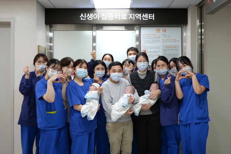 해운대백병원 신생아집중치료지역센터 의료진이 183일간의 치료 끝에 건강하게 퇴원한 세쌍둥이, 부모와 함께 기념 촬영하고 있다. 앞줄 왼쪽 두번째 정미림 센터장. 해운대백병원 제공
