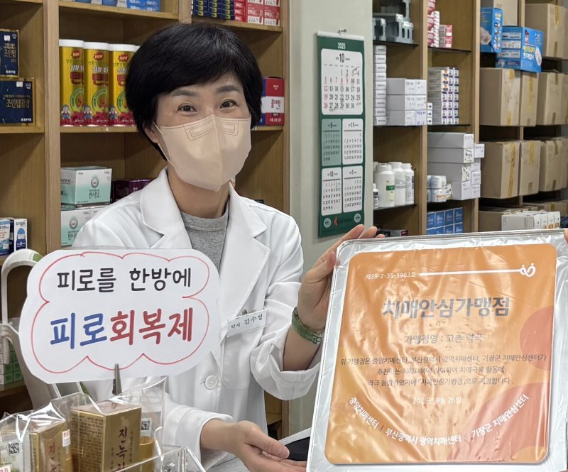 기장군 철마면 고촌약국 김수정 대표가 기장군 치매안심가맹점 지정 현판을 전달 받고 있다.(기장군 제공. 재판매 및 DB금지)