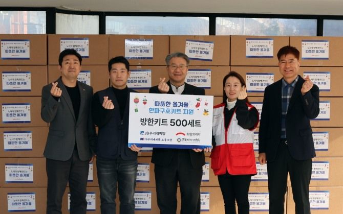 JB우리캐피탈과 희망브리지가 전국노숙인시설협회에 방한키트를 전달한 뒤 기념촬영을 하고 있다. 희망브리지 제공