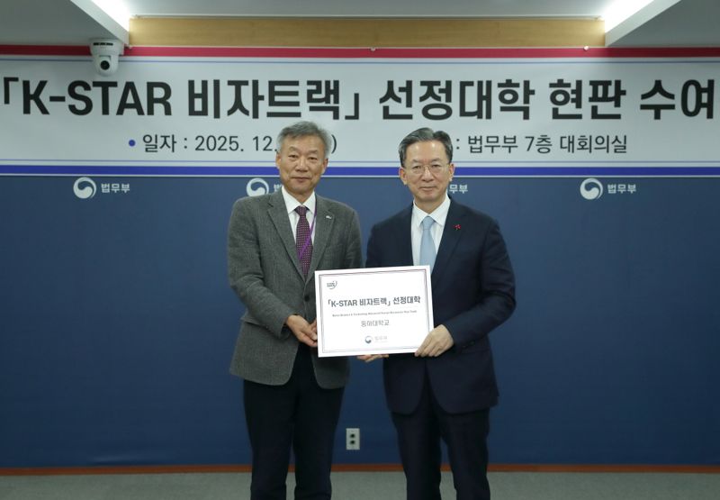 동아대 송강직 대학원장(왼쪽)이 'K-STAR 비자 트랙' 선정 대학 현판 수여식에서 과 정성호 법무부 장관과 기념사진을 촬영하고 있다. 동아대 제공
