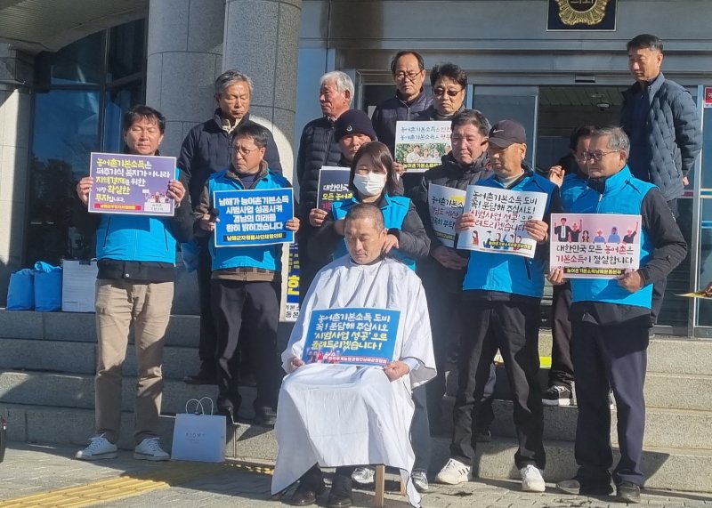 [창원=뉴시스]홍정명기자=9일 오전 경남도의회 현관 앞에서 더불어민주당 소속 류경완(남해) 도의원이 농어촌기본소득운동경남연합, 남해군농어촌기본소득추진연대와 남해군 농어촌기본소득 시범사업 도비 예산 전액 복원을 촉구하는 기자회견을 마친 후 삭발하고 있다.2025.12.09. hjm@newsis.com