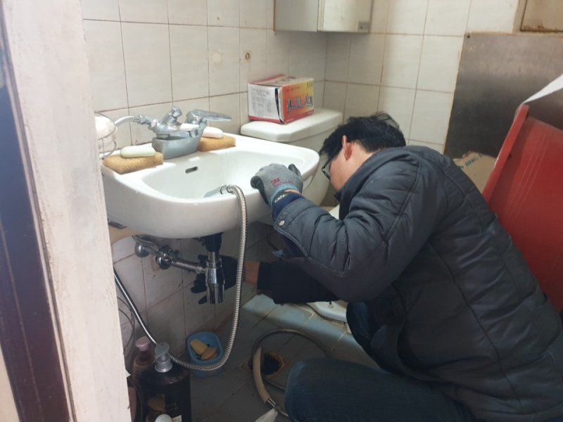 [울산=뉴시스] 주택을 방문해 세면대 배관을 수리하고 있는 울산 남구 OK생활민원기동대. (사진=울산 남구 제공) photo@newsis.com