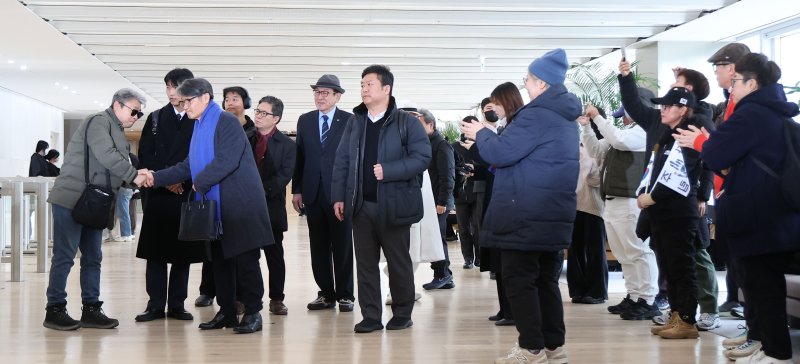 [서울=뉴시스] 김선웅 기자 = 최재영 목사가 9일 서울 종로구 김건희특검팀(특별검사 민중기)에서 열리는 '디올백 수수 의혹' 관련 참고인 조사에 출석하며 동행한 지인들과 인사를 나누고 있다. 최 목사는 지난 2022년 9월 당시 영부인 김건희 여사에게 300만원 상당의 디올백을 선물하고 이 과정을 몰래 촬영해 인터넷에 유포한 바 있다. 2025.12.09. mangusta@newsis.com