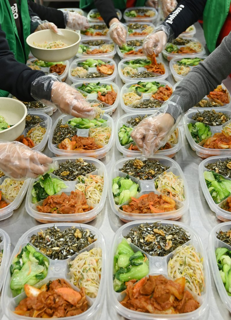 [수원=뉴시스] 김종택 기자 = 9일 경기 수원시 권선구 평동 행정복지센터에서 새마을 부녀회 회원들이 관내 독거노인 등 취약계층에 전달할 반찬을 만들어 용기에 담고 있다. 2025.12.09. jtk@newsis.com