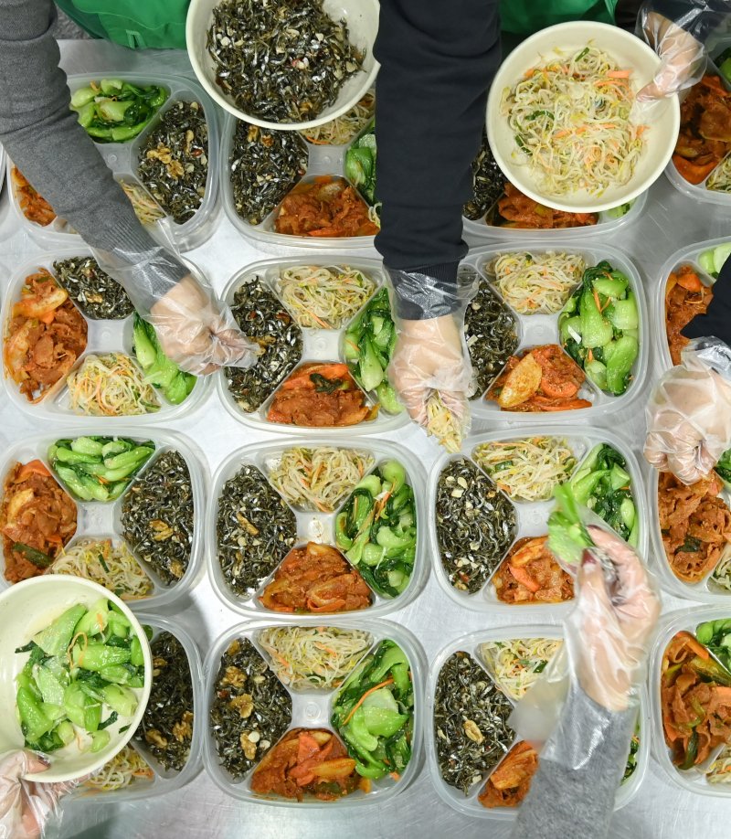 [수원=뉴시스] 김종택 기자 = 9일 경기 수원시 권선구 평동 행정복지센터에서 새마을 부녀회 회원들이 관내 독거노인 등 취약계층에 전달할 반찬을 만들어 용기에 담고 있다. 2025.12.09. jtk@newsis.com