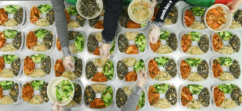 [수원=뉴시스] 김종택 기자 = 9일 경기 수원시 권선구 평동 행정복지센터에서 새마을 부녀회 회원들이 관내 독거노인 등 취약계층에 전달할 반찬을 만들어 용기에 담고 있다. 2025.12.09. jtk@newsis.com