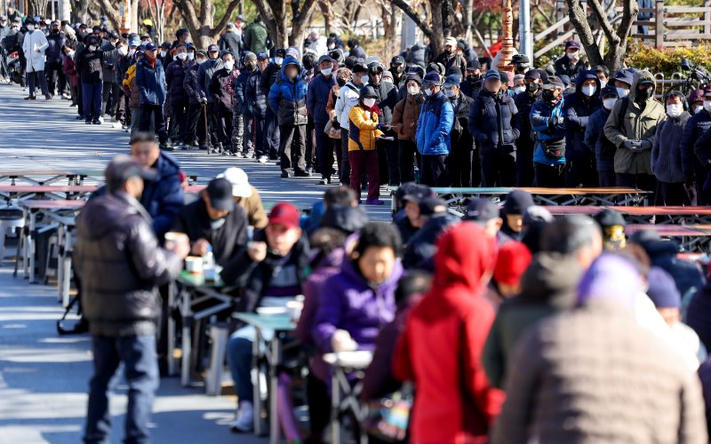 [대구=뉴시스] 이무열 기자 = 쌀쌀한 날씨를 보인 9일 대구 달서구 두류공원 사랑해밥차 무료 급식소를 찾은 어르신들이 점심 배식을 받기 위해 줄을 서고 있다. 2025.12.09. lmy@newsis.com