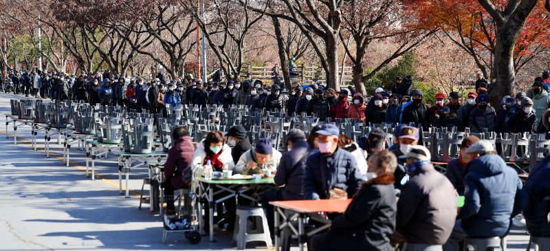 [대구=뉴시스] 이무열 기자 = 쌀쌀한 날씨를 보인 9일 대구 달서구 두류공원 사랑해밥차 무료 급식소를 찾은 어르신들이 점심 배식을 받기 위해 줄을 서고 있다. 2025.12.09. lmy@newsis.com