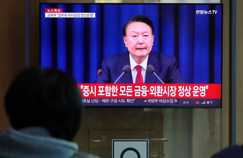 [서울=뉴시스] 김혜진 기자 = 윤석열 대통령이 비상계엄 해제를 선언한 지난해 12월4일 오전 서울역 대합실에서 시민들이 관련 뉴스를 보고 있다. 2024.12.04. jini@newsis.com