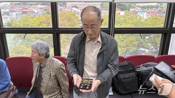 고(故) 이상규 소령의 장남 이동주 씨가 지난 10월 14일 창원지법 법정동에서 이 소령의 재심 첫 공판 직후 만난 취재진에게 이 소령의 계급장과 견장을 들어 보이고 있다.2025.10.14/뉴스1 강정태 기자