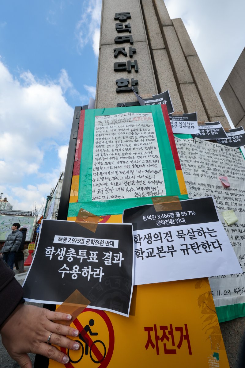 동덕여자대학교 학생들이 9일 오후 서울 성북구 동덕여대 정문 앞에서 제58대 총학생회 비상대책위원회·중앙운영위원회 주최 '공학전환에 대한 8000 동덕인 총투표 결과 전달 기자회견'을 마친 뒤 공학 전환 반대 손팻말을 정문에 붙이고 있다. ⓒ News1 안은나 기자