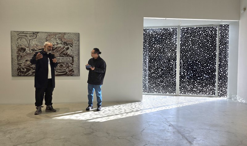 [사진=박현주 미술전문기자] 9일 서울 국제갤러리 K3 전시장에서 다니엘 보이드가 자신의 신작 앞에서 작업 방식을 설명하고 있다.작품 뒤편의 점무늬 패널을 통과한 햇빛이 바닥 위로 흘러들며, 보이드 특유의 ‘점 우주’를 전시장 전체로 확장시킨다. 2025.12.09. hyun@newsis.com *재판매 및 DB 금지